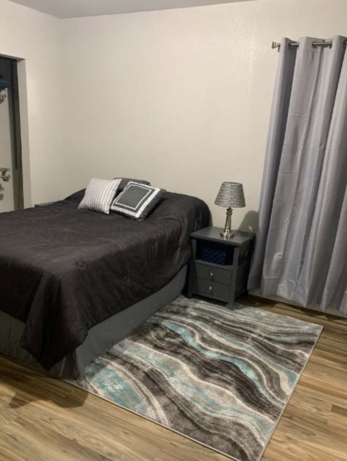 Wren B bedroom with bed, nightstand and rug
